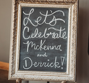 Chalkboard welcome sign reading “Let’s Celebrate McKenna and Derrick” created by our day-of coordinator at the Crossroads, Kansas City wedding venue.