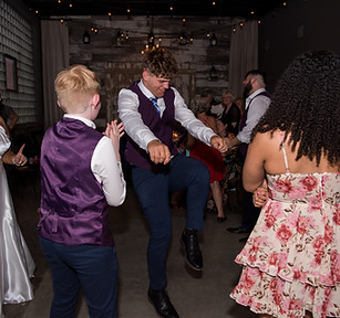 Male guest dancing during a wedding reception at the Crossroads, Kansas City venue, showcasing lively and budget-friendly all-inclusive wedding festivities.