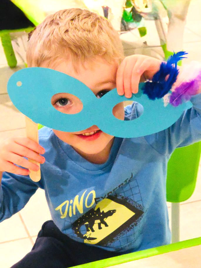 a boy wearing blue has paper shaped eye glass, the paper is blue