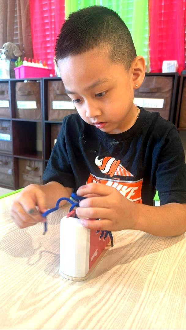 A boy practicing shoe tie