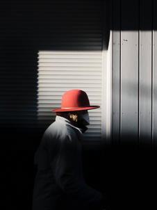 Street Fotografie von Guido Klumpe. frau mit rotem hut im Lichtspot