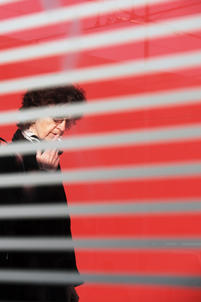 Street Fotografie von Guido Klumpe. Frau raucht hinter streifen