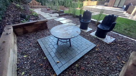 Porcelain stepping stone, granite fire pit, slate water feature & oak sleeper raised beds.