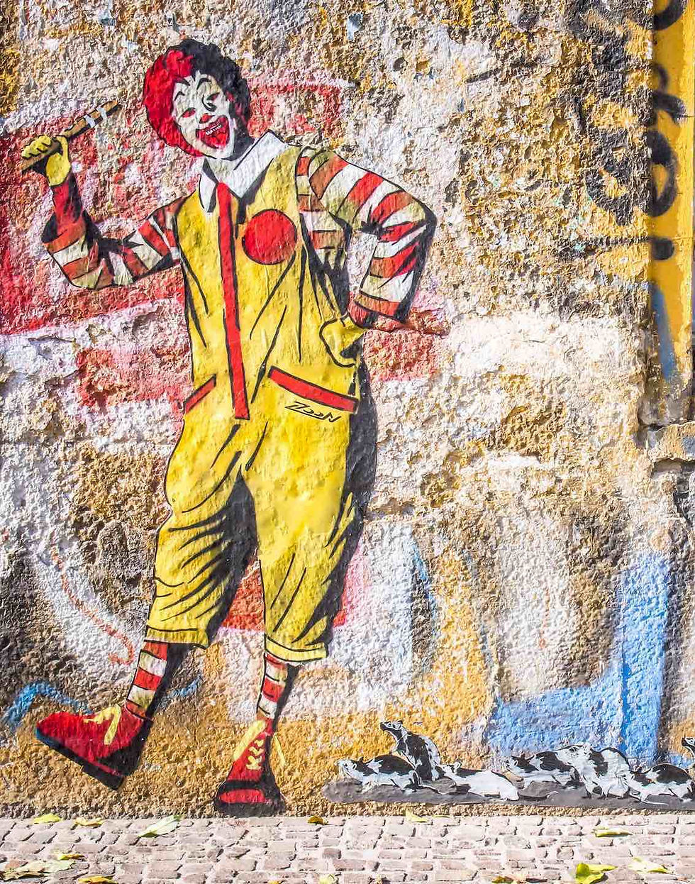 A chalk rendering of Ronald, McDonald’s clown mascot, leading rats with his flute (à la Robert Browning’s Pied Piper of Hamelin)
