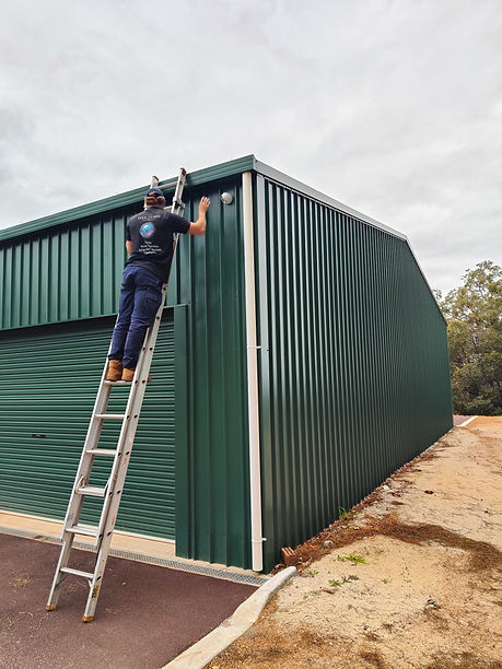 Security Technician on a ladder installing a security camera