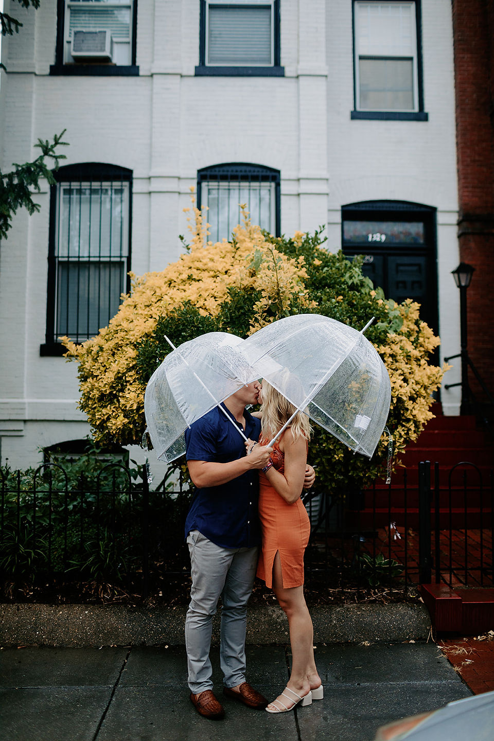 Alyssa & Kieran kiss under clear umbrellas