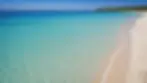 Eye-level view of a pristine beach with crystal clear waters