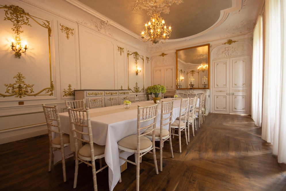 The large, ornate dining room with chandelier, which holds up to 18 people for dining.