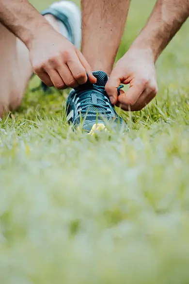 hands-tying-shoe-laces-on-a-running-shoe.webp