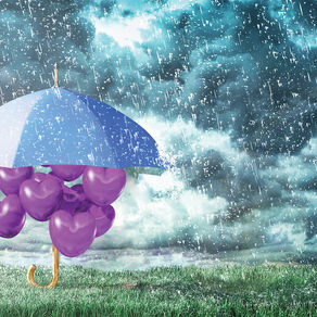 A gray umbrella shelters several purple, heart shaped balloons from the rain.