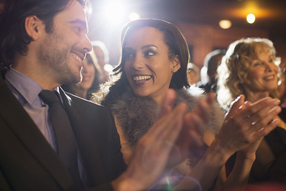 Couple clapping in the audience at a theater performance