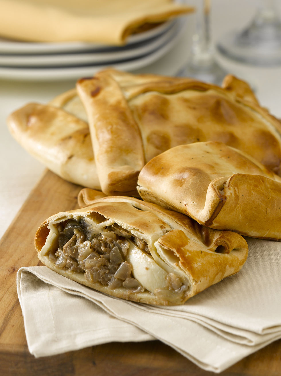 Vista cercana de empanadas de pino recién horneadas con masa dorada y relleno jugoso