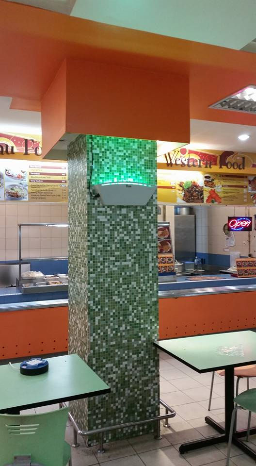 Thumbnail: IKAWA PRO IK-TAC-700 UV light trap installed on mosaic tiled pillar in food court, emitting green light for insect control