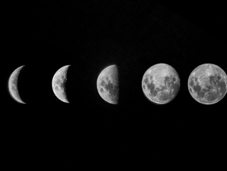 Five moon phases from crescent to full against a black background, showcasing subtle surface details.