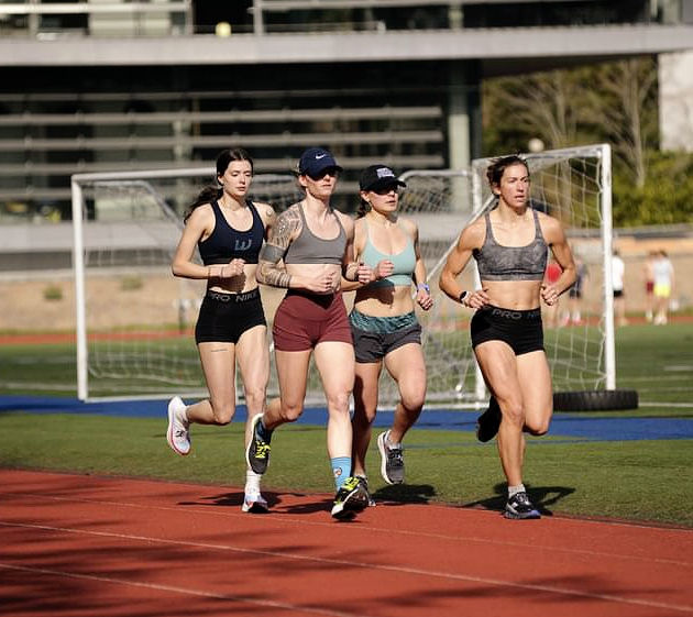 Mo Frazier running with group of WWU female track athletes at practice