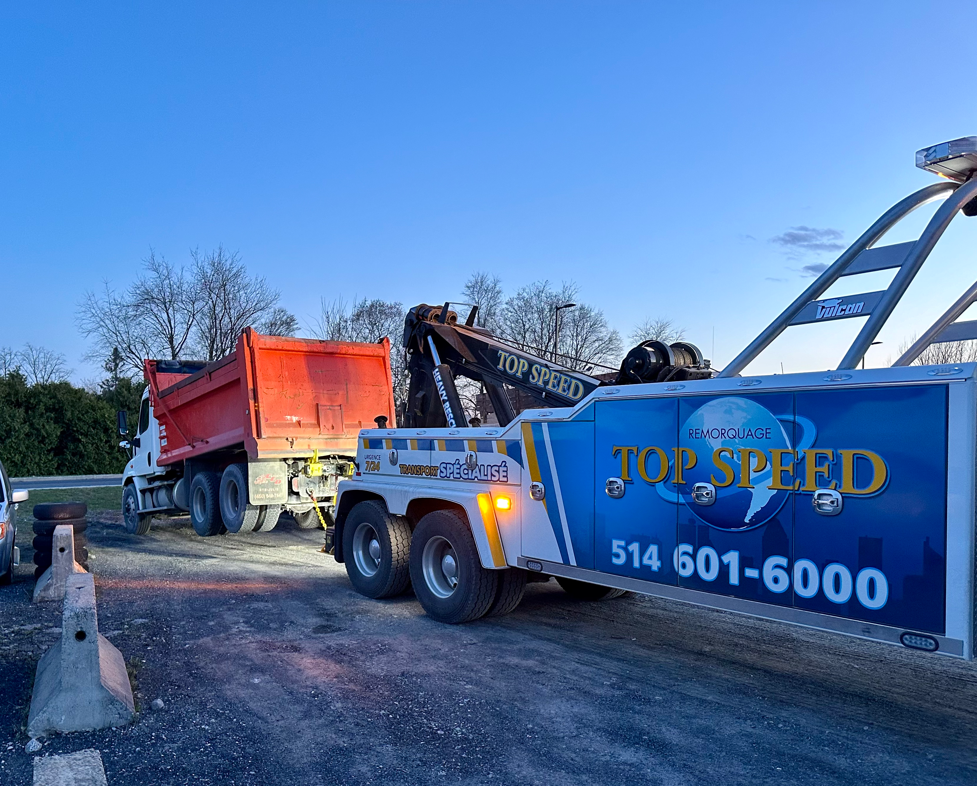 Dépanneuse à flèche et camion rouge en hiver