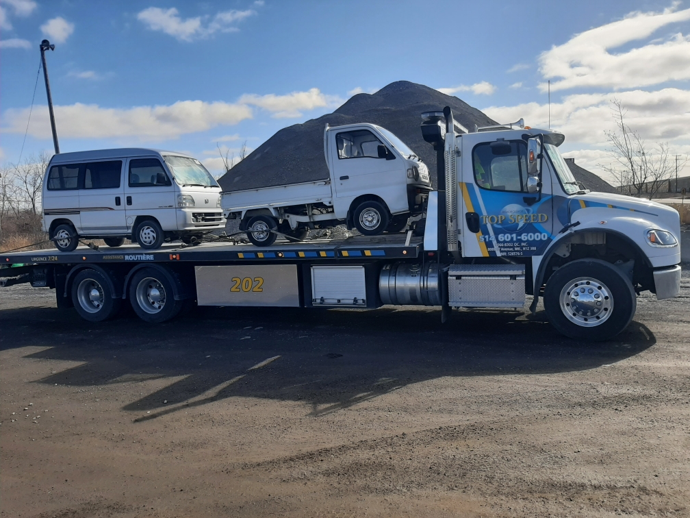 Plateforme transportant un véhicule utilitaire blanc