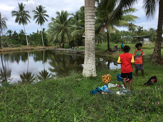 A group of people gathered around a lake in Papua New Guinea