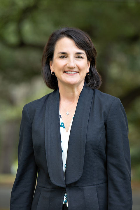 professional corporate headshot of a woman in a suit jacket