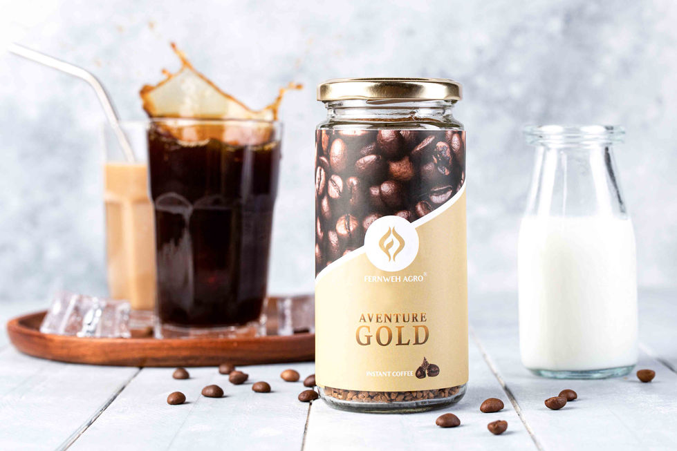 A high-speed action photograph capturing a dynamic, messy liquid splash exploding out of a glass of iced coffee behind a standing jar of Fernweh Agro Aventure Gold next to a small glass bottle of fresh milk.
