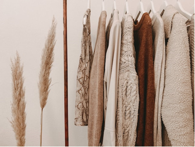 winter clothes on a rack that you should declutter before winter