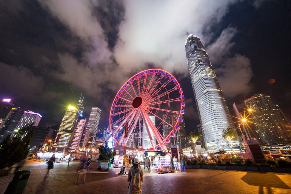 People in Hong Kong walking near the Ferris wheel