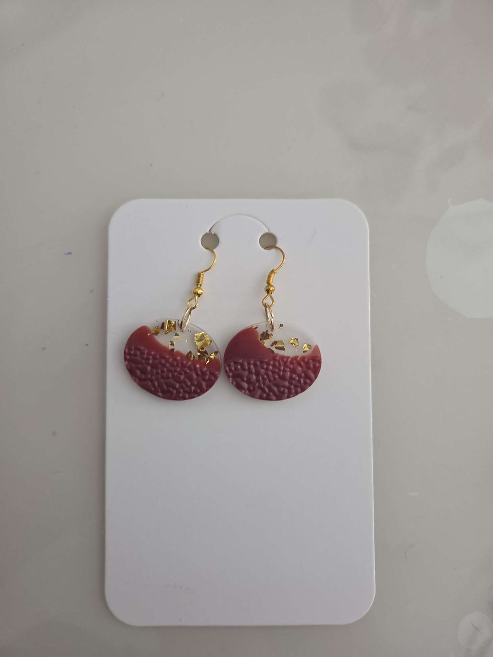 Boucles d'oreilles rondes petit modele, boucles d'oreilles ronde, sélenite, sur un présentoir blanc.