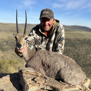 hunter with vaalrebuck on mountain in the Eastern Cape