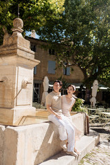 Couple laughing together while sitting on the fountain at Gordes