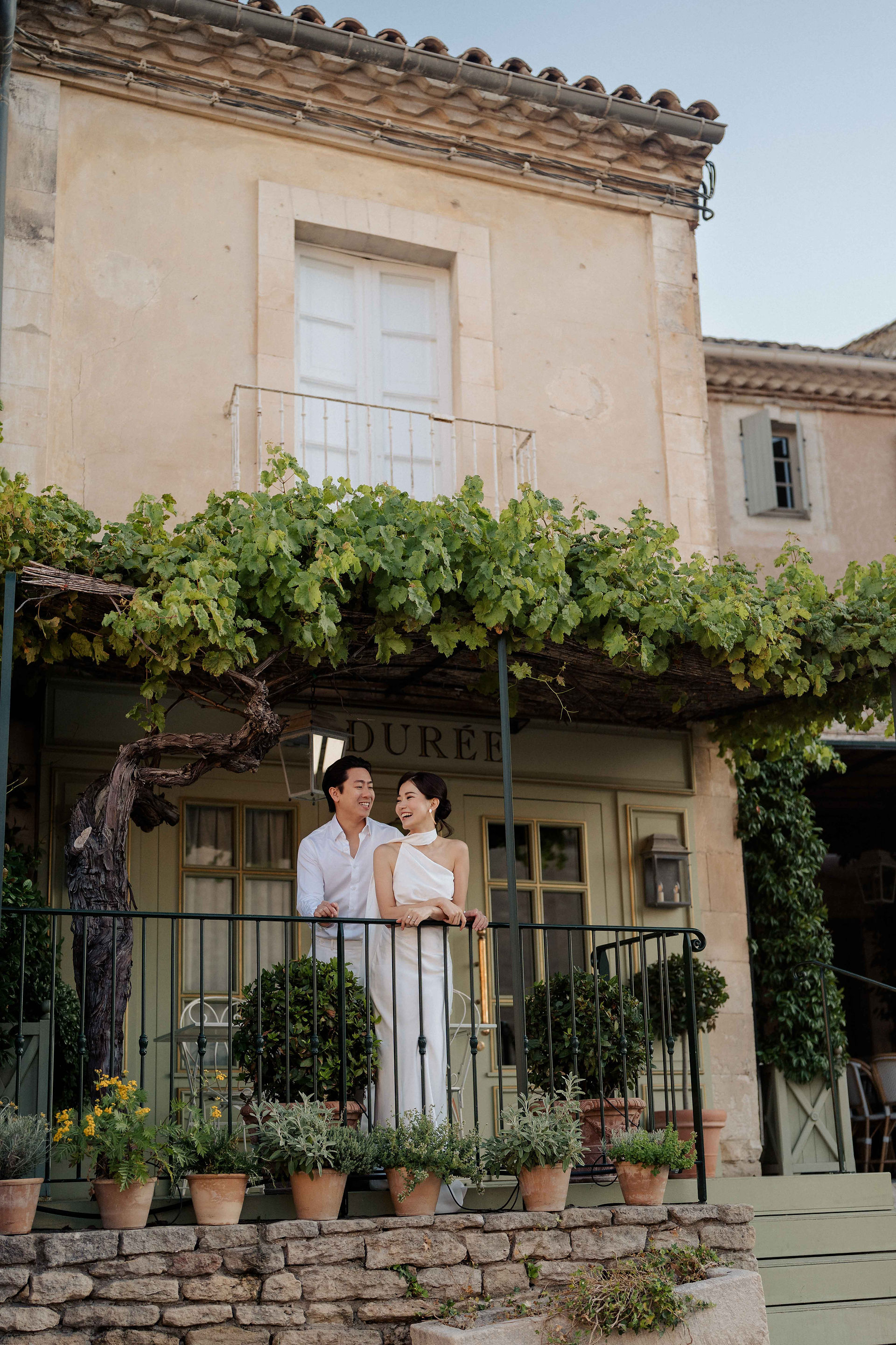Couple laughing together at the balcony of a shop at Gordes for their prewedding experience