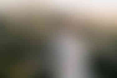 Couple hugging together at sunrise with Gordes hilltop view in the background for their prewedding