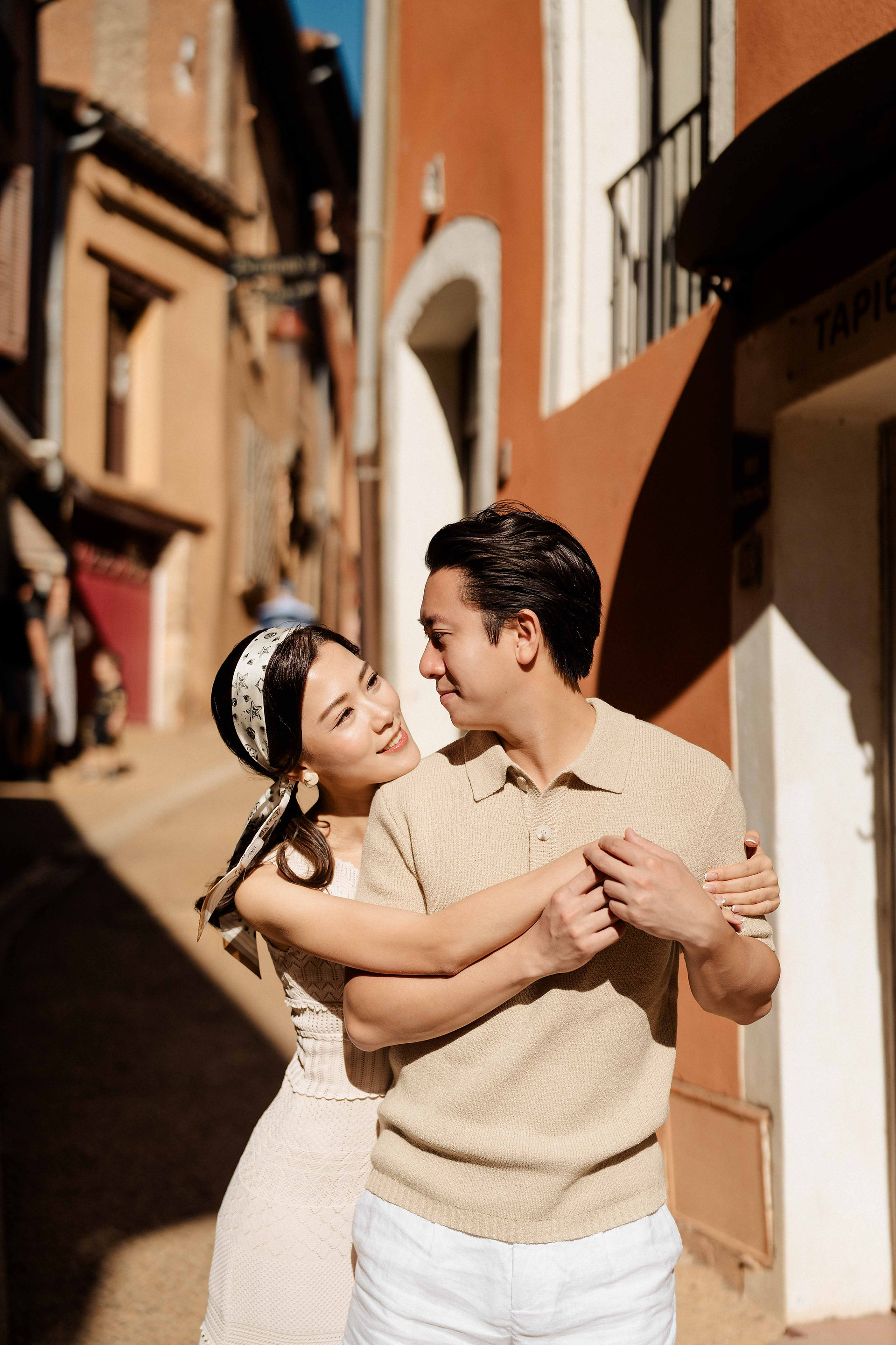Couple hugging together for their prewedding in Roussillon little alleys with orange buildings around