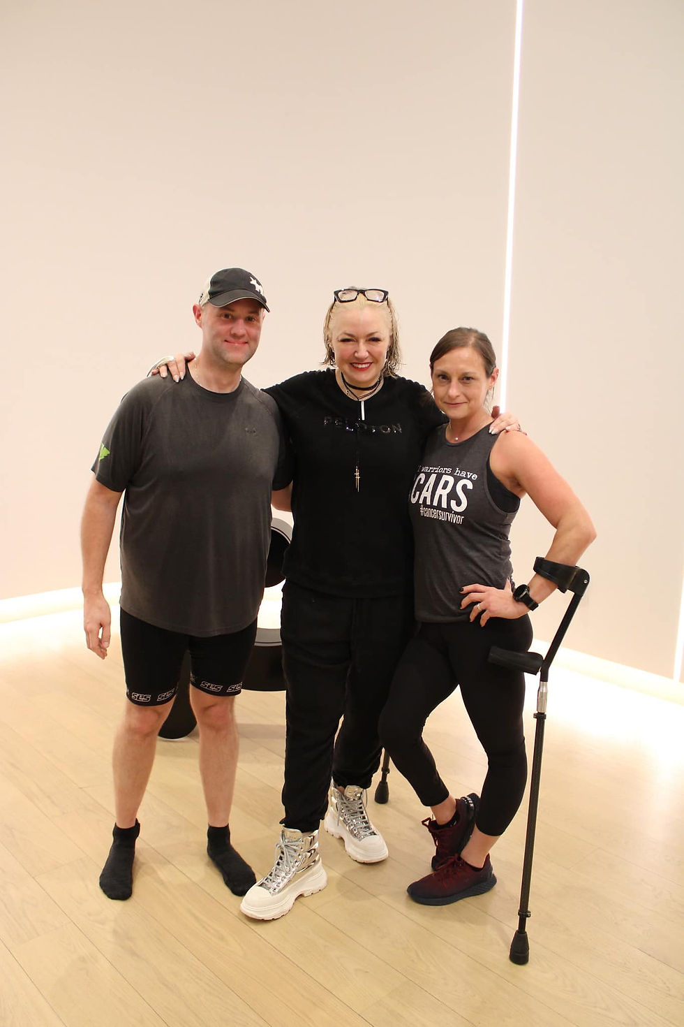 Photo of Devann standing with her husband, Tom, and Christine D'Ercole of Peloton.