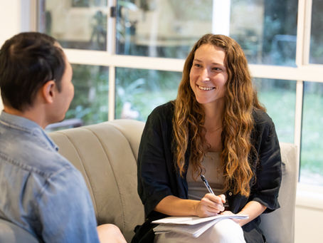 A counsellor and person sitting on a chair talking