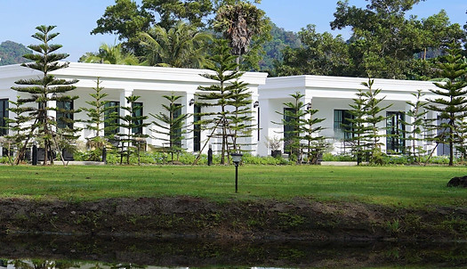 sunrise over the pond and the green lawn and the villas of Tarn Villa Krabi