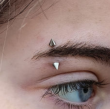 Healed eyebrow piercing with spikes in titanium
