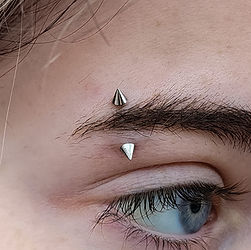 Healed eyebrow piercing with spikes in titanium