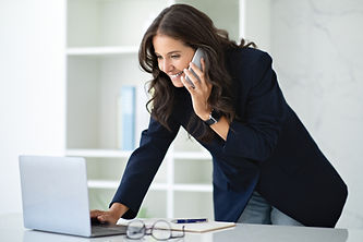 mature-businesswoman-talking-phone-working-laptop-office.jpg