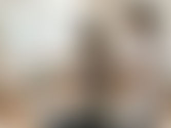 A physiotherapist guides a seated patient through shoulder rehabilitation exercises using a resistance band in a bright therapy clinic, illustrating active recovery stages related to how long does a dislocated shoulder take to heal.