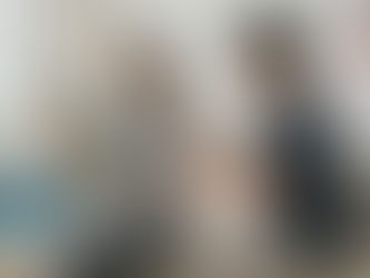 A physiotherapist guides a seated woman using a resistance band during supervised bicep tendonitis exercises to strengthen the shoulder and support tendon recovery