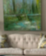 Green and blue abstract painting by Stephanie Evans displayed above a tufted sofa.