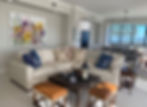 Colorful floral abstract painting by Stephanie Evans displayed above a leather sofa.