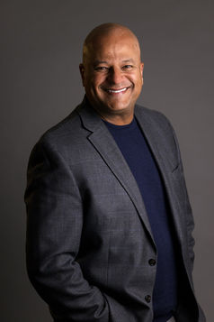 Studio portrait of a man wearing a blazer and smiling, photographed in a Nashville, Tennessee studio