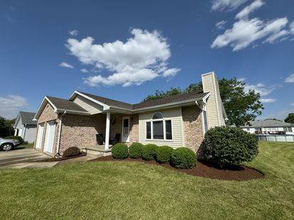 Front yard landscaping of a house in Orland Hills, IL has new brown mulch