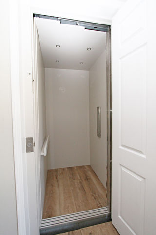 a small elevator with a wooden floor and white walls