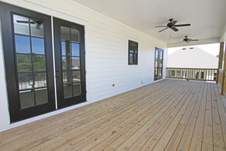 a large wooden deck with a ceiling fan