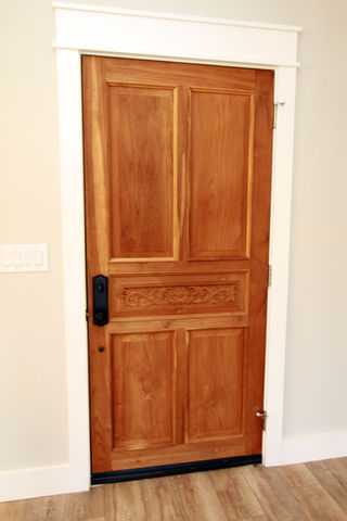 a carved wooden door with a black handle