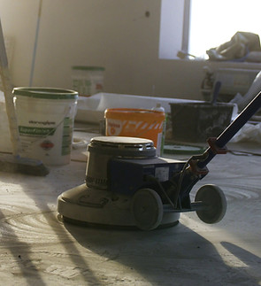 builder-polishing-mortar-floor-at-construction-site-of-new-appartments-mechanized-grou-SBI