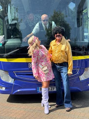 A woman in a pink floral dress with knee-high boots and a man in a yellow ruffled shirt