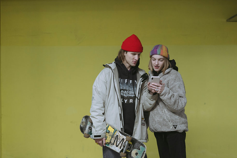 Two skateboarders looking at smartphone screen